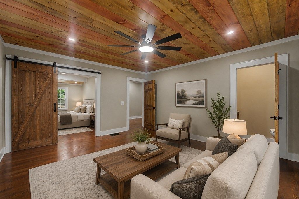 Family room with a sliding barn door to a bedroom, shown with virtual furniture