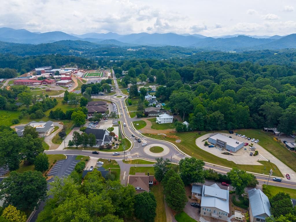 Aerial view of the area around the house, with the roundabout, town, and mountains beyond