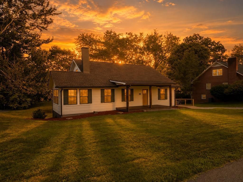 Front of the house at dusk with the windows lit