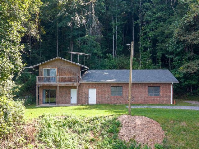 Front of the brick and wood-sided home with the upper deck
