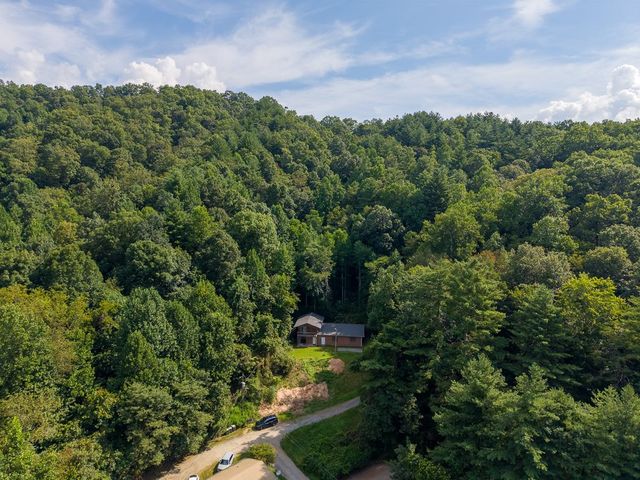 Aerial view of the home in the wooded valley