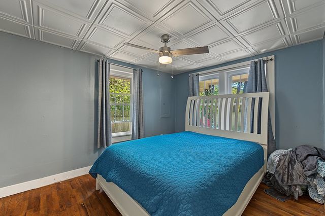 Bedroom with a pressed-tile ceiling and two windows