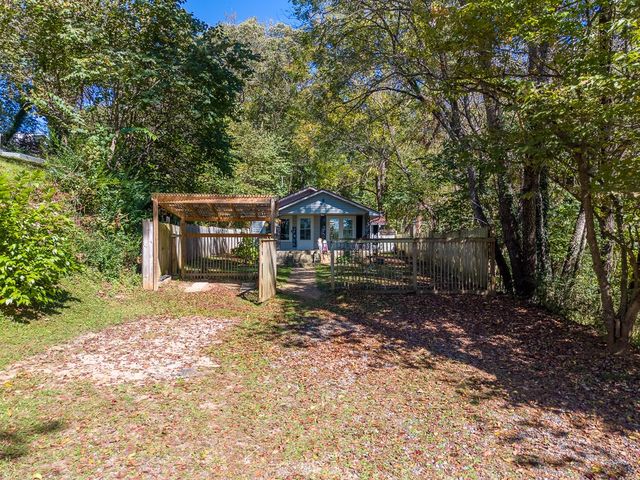 Parking area and pergola gate in front of the house