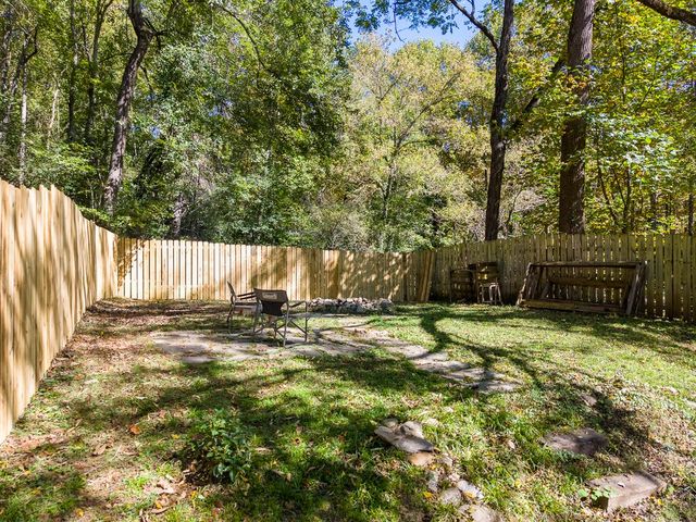 Fenced backyard with a stone fire pit