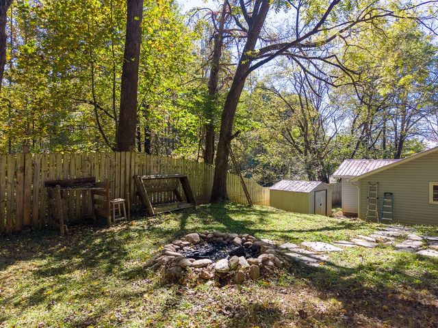 Backyard with the fire pit and outbuildings